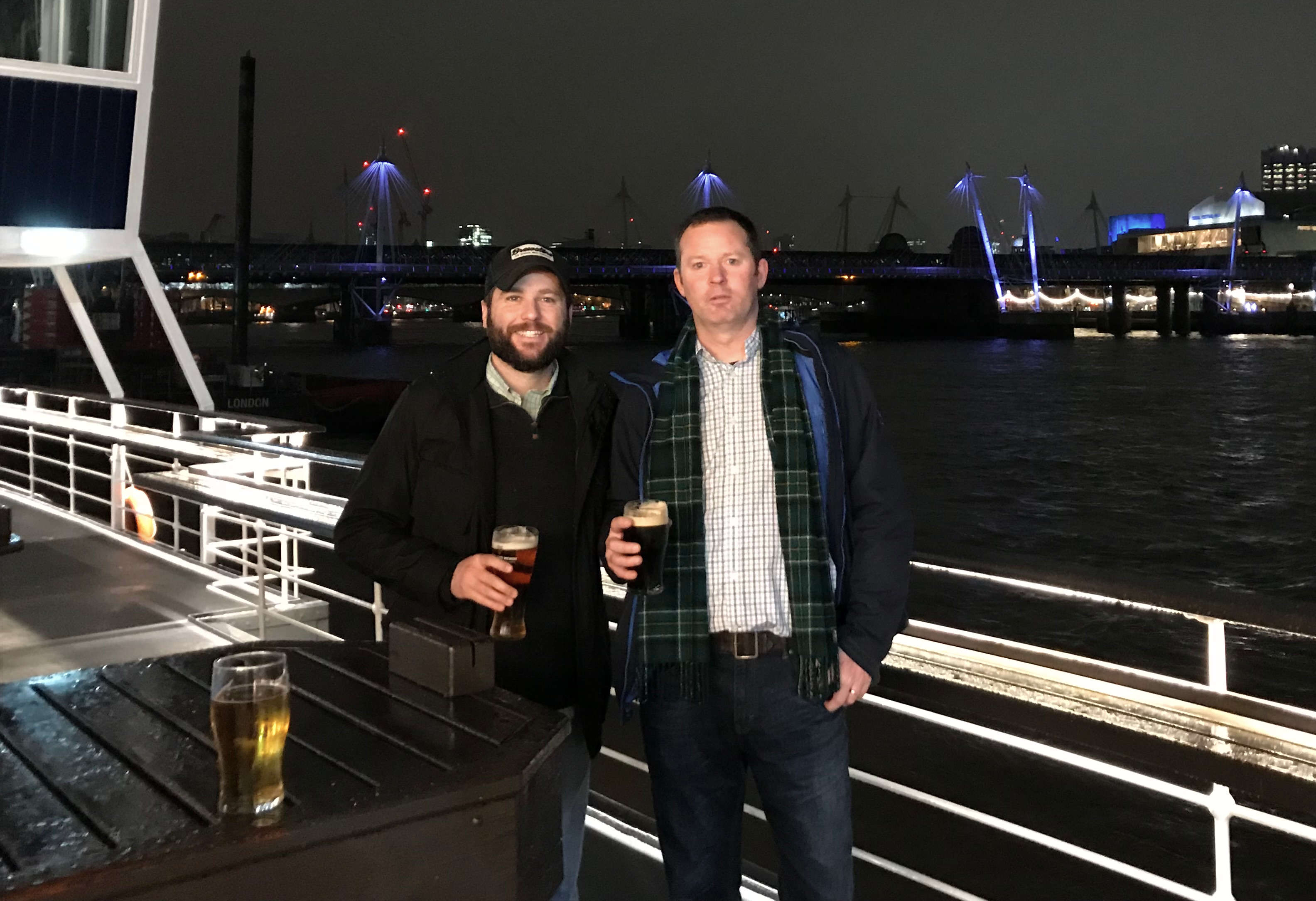 Jeff Coyle and Kevin Coyle drinking beer on a boat in London.