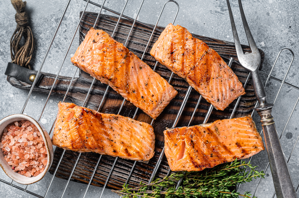 Grilled salmon fillets steaks with salt pepper and herb on grill - pairing with Golden Ale